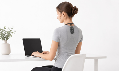 Femme portant le correcteur de posture dos et nuque vibrant TOPAZE en travaillant sur son ordinateur portable